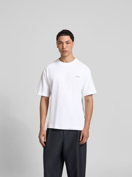 Männermodel trägt Regular Fit T-Shirt aus reiner Baumwolle von Closed, weiß, Rundhalsausschnitt, Label-Print, Kurzarm, Ganzkörperansicht von vorne.