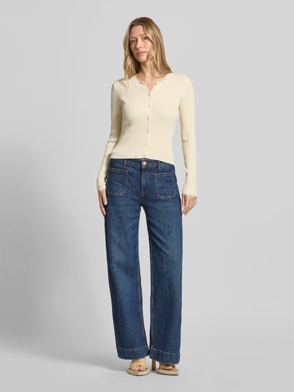 Frauenmodel trägt Slim Fit Strickjacke aus Viskose-Mix Modell 'Wonder' von Vero Moda, Optik: Unifarben, Passform: Slim-Fit, Spitzen-Besatz, Rundhals, Langarm, Materialverarbeitung: Rippstrick, Ganzkörperansicht von vorne.