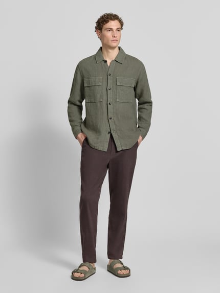 Männermodel trägt Relaxed Fit Freizeithemd aus reinem Leinen Modell 'LOCKY' von BOSS Orange, Optik: Unifarben, Ganzkörperansicht von vorne. Materialverarbeitung: Flammgarn. Passform: Relaxed-Fit. Mit Kentkragen, durchgehender Knopfleiste, Label-Patch, Ärmelform: Langarm, Manschette, Brusttaschen.