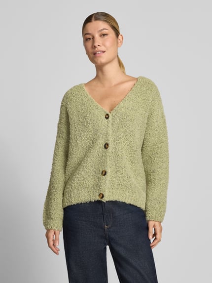 Frauenmodel trägt Cardigan mit V-Ausschnitt Modell 'So44fia' von ZABAIONE in Hellgrün, grobe Textur, Knopfleiste, Nahaufnahme Oberkörper. Material-Mix mit Viskose-Anteil und geradem Schnitt, Rückenlänge 56 cm, Ärmellänge 47 cm.