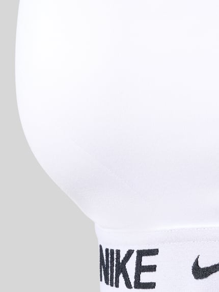 Vrouwenmodel draagt Bustier met Label-Details en verstelbare bandjes van NIKE TRAINING, witte stof, stretch, detailopname onderbust.