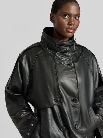 Frauenmodel trägt Regular Fit Jacke in Leder-Optik Modell 'Zavic' von Gestuz, schwarz, Stehkragen, doppelte Knopfleiste, Nahaufnahme Oberkörper.
