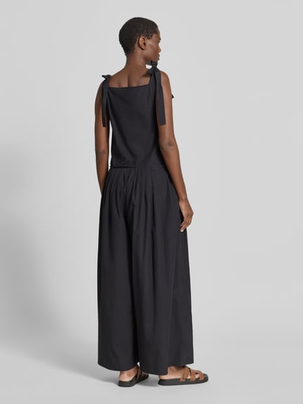 Frauenmodel trägt Loose Fit Jumpsuit aus reiner Baumwolle Modell 'AGGUATI' von Weekend Max Mara, Optik: Unifarben, A-Linien-Passform, Neckholder mit Schleifenband, seitliche Eingrifftaschen, Ganzkörperansicht Rückansicht.
