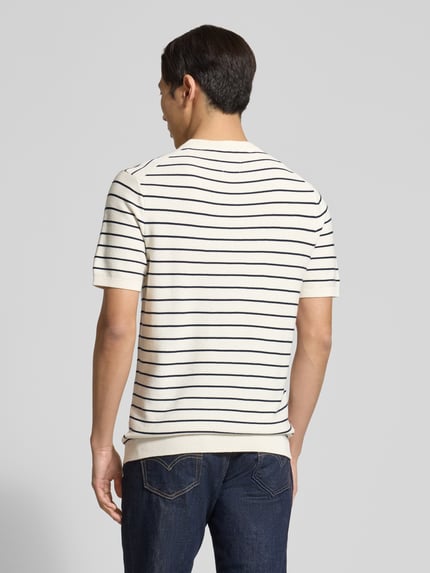Männermodel trägt Strickshirt mit geripptem Rundhalsausschnitt von MCNEAL, Reine gewachste Baumwolle, Gerader-Schnitt, Gerippte-Abschlüsse, Rückenlänge 72 cm, Ärmellänge 25 cm, Creme mit dunklen Streifen, Ganzkörperansicht Rückansicht.