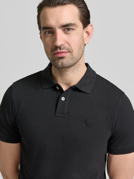 Mężczyzna nosi Slim Fit Poloshirt mit Logo-Stitching von MCNEAL z czystej bawełny, krój slim fit, kolor czarny, polokołnierzyk, długość tyłu w rozmiarze M: 70 cm, zbliżenie górnej części ciała z przodu.