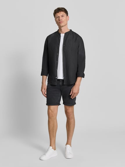 Mannelijk model draagt Slim Fit Jeansshorts aus Baumwoll-Mix Modell 'NAAILO' van Armedangels in denimlook met labelpatch, riemlussen, knoop- en ritssluiting, pijpboord met omslag, 5-pocketmodel, katoenmix, donkere tinten, rechte lijnen, gladde textuur. Ganzkörperansicht van voren.