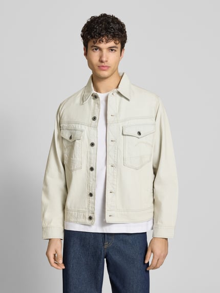 Männermodel trägt Jeansjacke mit Brusttaschen Modell 'Dakota' von G-Star Raw aus Reine Baumwolle, Relaxed-Fit, Ganzkörperansicht von vorne.