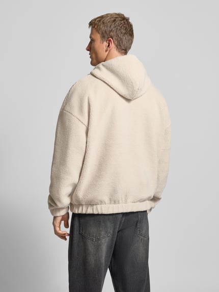 Männermodel draagt Fleecepullover met ritssluiting model 'Olten' van Pegador, heren relaxed fit, capuchon met tunnelkoord, kangoeroezak, labelstitching, ruglengte maat M 72 cm, mouwlengte maat M 61 cm, lichte structuur, effen beige tint, ganzkörperansicht rugansicht.