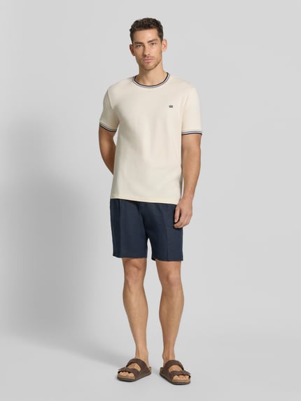 Männermodel trägt T-Shirt mit Kontraststreifen und Rundhalsausschnitt von Christian Berg Men aus Baumwoll-Elasthan-Mix, Regular-Fit, Rückenlänge bei Größe M 71 cm, helle und dunkle Farbtöne, glatte Textur, Ganzkörperansicht von vorne.