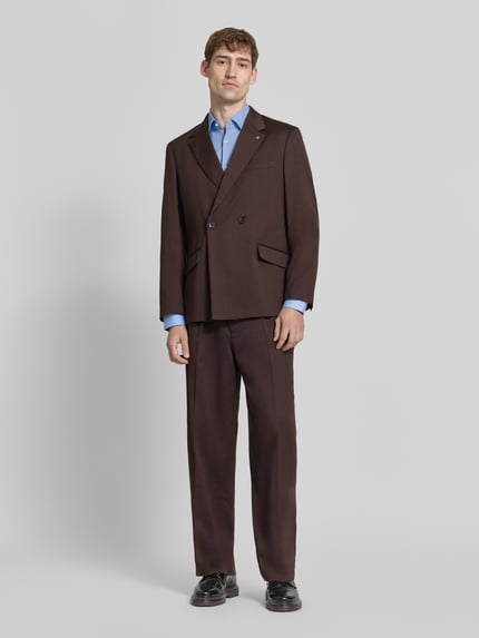 Männermodel trägt Regular Fit Sakko mit Woll-Anteil von Scotch & Soda in Dunkelbraun, Reverskragen, Doppelreiher, Ganzkörperansicht von vorne, Material-Mix, Brust- und Pattentaschen, Rückenlänge 74 cm, Schulterbreite 44 cm, Ärmellänge 65 cm.