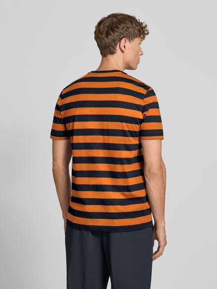 Mężczyzna nosi Regular Fit T-Shirt mit Logo-Stitching od Christian Berg Men, bawełna, krój regular fit, wyhaftowane logo, okrągły dekolt, długość tyłu w rozmiarze M: 70 cm, poziome pomarańczowo-czarne paski, tekstura gładka, widok całej sylwetki z tyłu