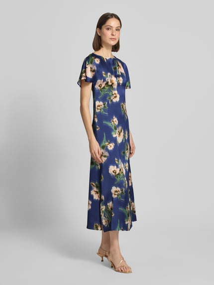Vrouwenmodel draagt cocktailjurk van satijn, a-lijn, midilengte, blauw met bloemendessin, Cocktailkleid in Midilänge Modell 'Leonie' van GUIDO MARIA KRETSCHMER WOMAN, korte mouwen, sleutelgatsluiting achter, ruchthals, ruglengte maat 36: 124 cm, borstwijdte 39 cm, mouwlengte 20 cm, volledig zichtbaar van voren.