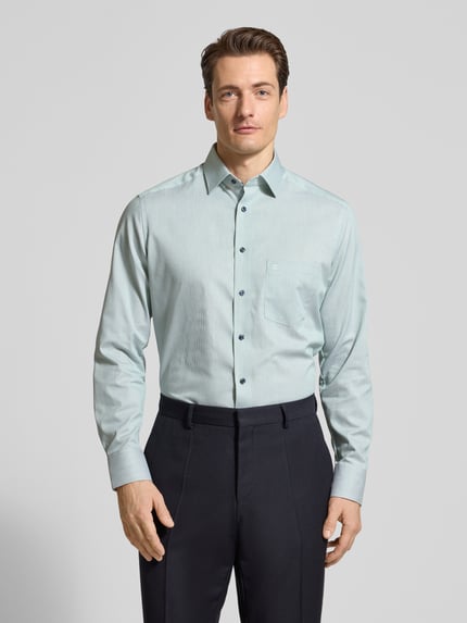 Männermodel trägt Regular Fit Business-Hemd mit Kentkragen van OLYMP in lichtblauw, katoen, borstzak met logo, vooraanzicht bovenlichaam.