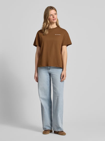 Vrouwenmodel draagt Relaxed Fit T-shirt uit zuiver katoen - Special Drop van Marc O'Polo Denim, look: effen, rugprint, labelprint, ronde hals, korte mouw, puur katoen, effen bruin, recht model, vooraanzicht volledig lichaam