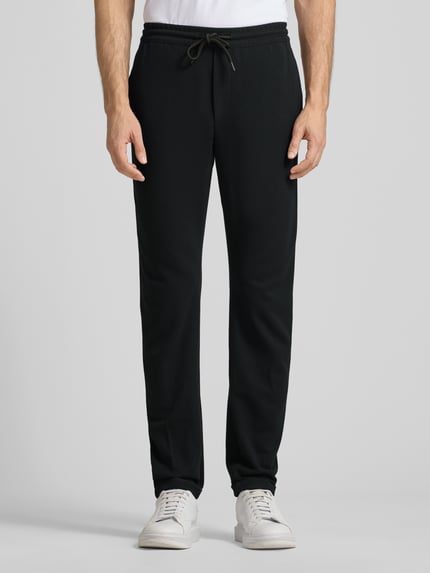 Mężczyznamodel nosi czarne Tapered Chino z wiskozą od Tom Tailor Denim, długie nogawki, kieszenie boczne, widok z przodu, całe ciało.