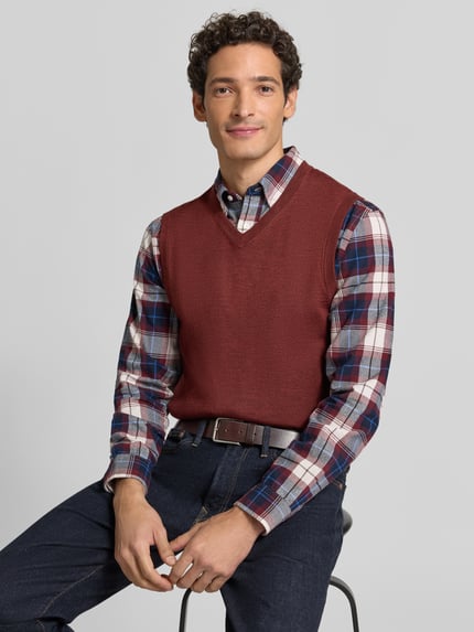 Männermodel trägt Slim Fit Pullunder aus Baumwoll-Mix mit V-Ausschnitt von Christian Berg Men, Strick-Optik, Nahaufnahme Oberkörper.
