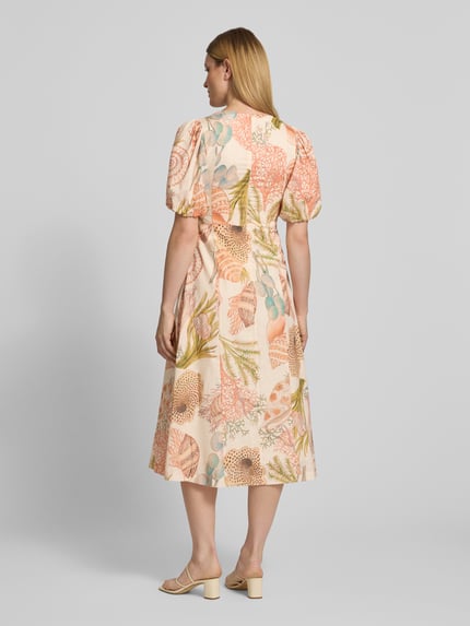 Vrouwenmodel draagt midi-jurk im allover-look met pofmouwen van Rich & Royal uit puur katoen, A-lijn, ruglengte maat 36: 122 cm, borstwijdte 45 cm, mouwlengte 33 cm, all-over pastelkleuren en zachte texturen, A-lijn silhouet, ronde hals, geheel lichaam rugaanzicht.