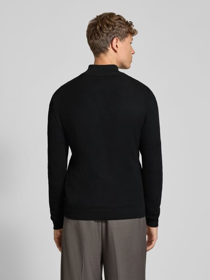 Männermodel trägt Regular Fit Troyer aus reiner Baumwolle von S.OLIVER CASUAL, schwarz, Strickoptik, hochgeschlossener Kragen, Ganzkörperansicht Rückansicht.