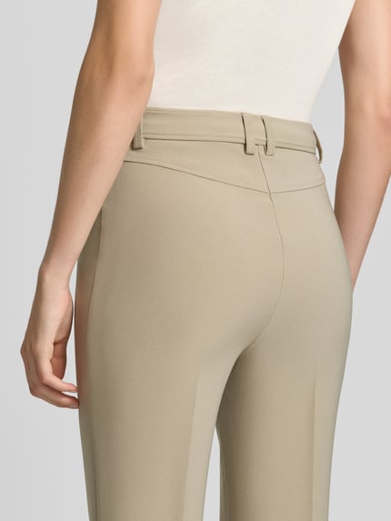 Vrouwenmodel draagt recht model 'C_Tana' broek van BOSS Orange in beige, gladde stof, detailopname achterkant.