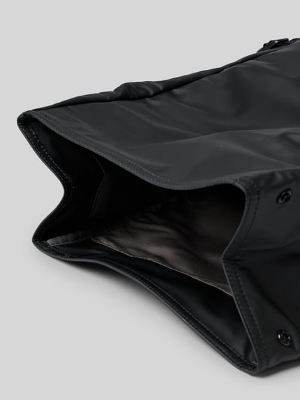 Produktfoto, Rolltop-Rucksack mit Label-Patch von CK Calvin Klein aus schwarzem Material, große Öffnung, glatte Textur, Detailaufnahme. Maße: 40x60x17 cm, Seitenfächer, verstellbare Schulterriemen, Klickverschluss, Tragehenkel.