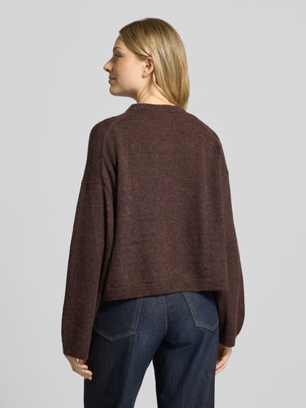 Frauenmodel trägt Cardigan aus Alpaka-Mix Modell 'MARWENI' von DRYKORN, braun meliert, entspannter Schnitt, Rückenansicht, Damenmode, Kontext: Relaxed Fit, Woll-Anteil, Rundhalsausschnitt, Knopfleiste, Rückenlänge ca. 51 cm, Ärmellänge ca. 70 cm.