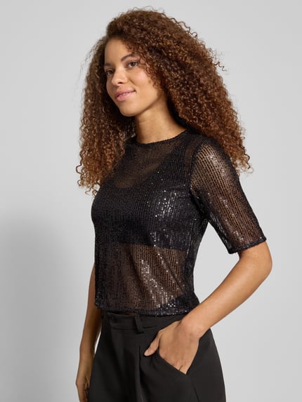 Frauenmodel trägt Shaped Fit T-Shirt mit Paillettenbesatz Modell 'JACK' von Pieces, glänzendes Mesh, schwarzer Farbton, Nahaufnahme Oberkörper.