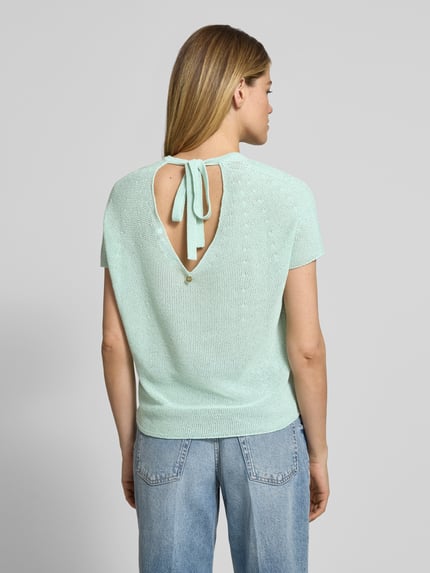 Frauenmodel trägt T-Shirt in Strick-Optik mit V-Ausschnitt von Rich & Royal, Damen T-Shirt aus Baumwoll-Mix, Straight Fit, Rückenlänge 40 cm, Ganzkörperansicht Rückansicht.