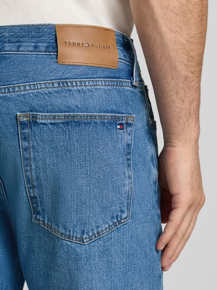 Männermodel trägt Straight Fit Jeans aus von Tommy Hilfiger, hellblaues Denim mit sichtbarer Gesäßtasche, Nahaufnahme Rückansicht. Herren Straight Fit Jeans von Tommy Hilfiger.
