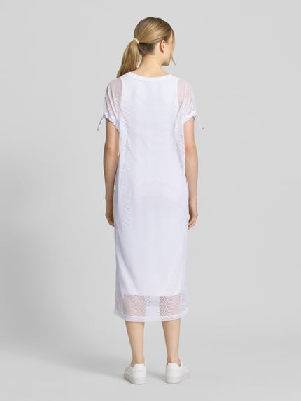 Frauenmodel trägt semitransparentes Midikleid mit Rundhalsausschnitt von Marc Cain in Weiß, Material-Mix mit Stretch-Anteil, gerader Schnitt, Rückansicht Ganzkörperansicht.