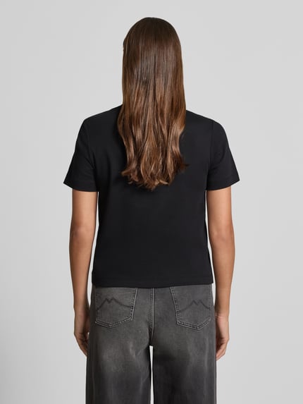 Männermodel trägt Boxy Fit T-Shirt aus reiner Baumwolle von s.Oliver RED LABEL, czarny kolor, krótki rękaw, krój boxy fit, widok całej sylwetki od tyłu.