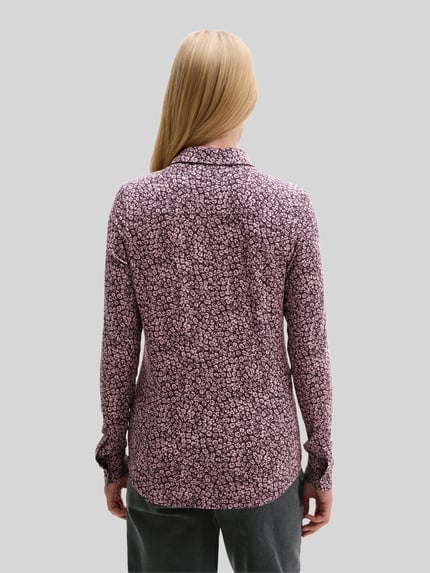 Frauenmodel trägt Longline Langarmbluse mit Label-Detail von Marc O'Polo in abstraktem, grafischem Allover-Muster, Ganzkörperansicht Rückansicht.