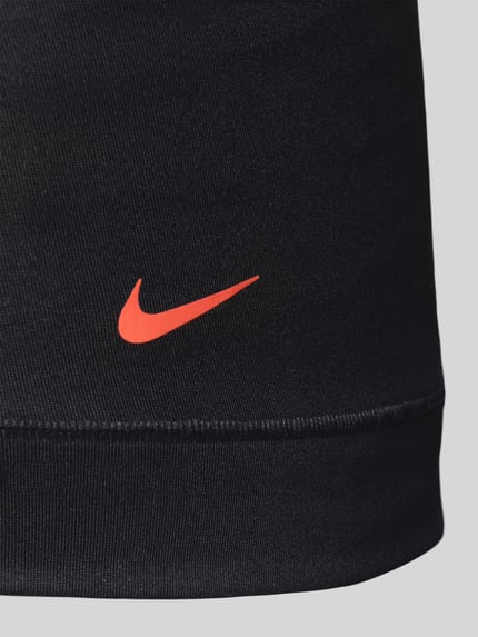 Männermodel trägt Micro Trunks im 3er-Pack mit Logo-Bund von Nike, schwarzer Material-Mix mit Stretch-Anteil, Logo-Print, Nahaufnahme Oberschenkel.