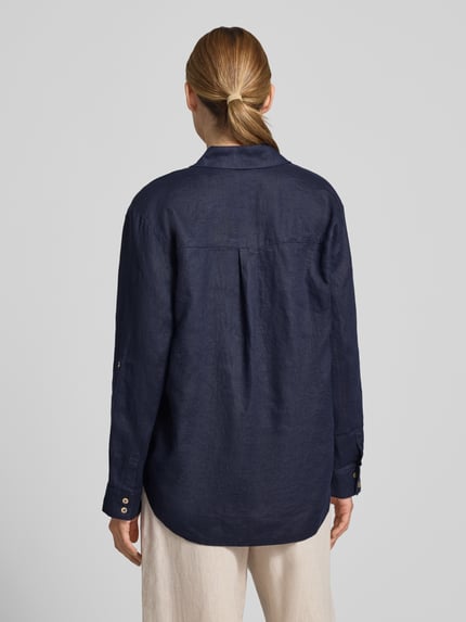 Frauenmodel trägt Regular Fit Leinenbluse mit V-Ausschnitt von Christian Berg Woman in Dunkelblau, reine Leinen, Hemdblusenkragen, Rückenlänge 72 cm, Ärmellänge 58 cm, Ganzkörperansicht Rückansicht.