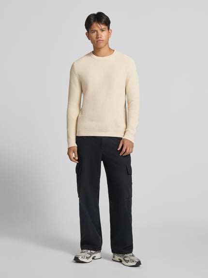 Männermodel trägt Regular Fit Strickpullover aus reiner Baumwolle von REVIEW, helle Farbe, lange Ärmel, Ganzkörperansicht von vorne.