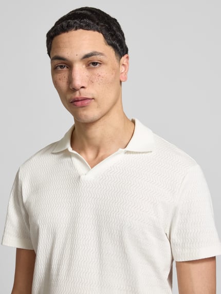 Männermodel trägt Regular Fit Polo-Shirt mit Strukturmuster Modell 'Heskild' von Blend, reine Baumwolle, kurzärmelig, Nahaufnahme Oberkörper.