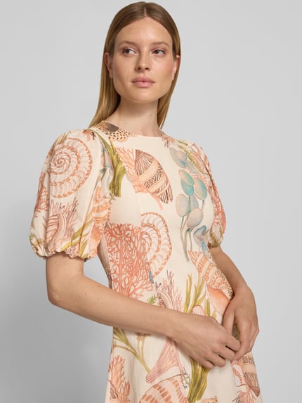 Vrouwenmodel draagt midi-jurk im allover-look met pofmouwen van puur katoen, A-lijn, ronde hals van Rich & Royal, detailopname bovenlichaam.