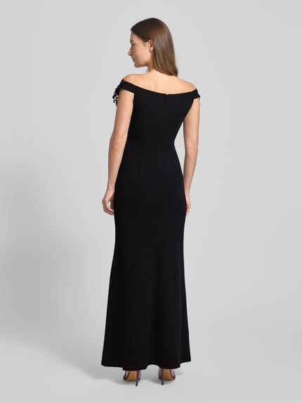 Vrouwenmodel draagt avondkleid im Off-Shoulder-Look van Lipsy in zwart, aansluitende pasvorm, rits, mix van materialen, volledige rugaanzicht.