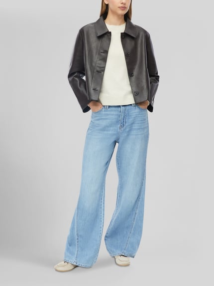 Frauenmodel trägt Slim Fit Pullover aus Viskose-Mix von s.Oliver RED LABEL in Creme mit glatter Textur, weite Jeans, Ganzkörperansicht von vorne.