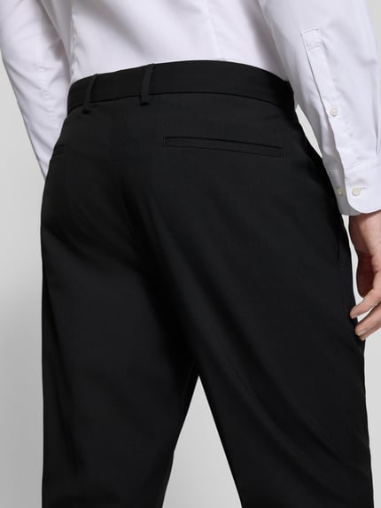 Männermodel trägt Anzughose mit Eingrifftaschen Modell 'Pure' von s.Oliver BLACK LABEL, schwarze Unifarbe, Detailaufnahme Rückansicht, Material-Mix mit Viskose-Anteil.