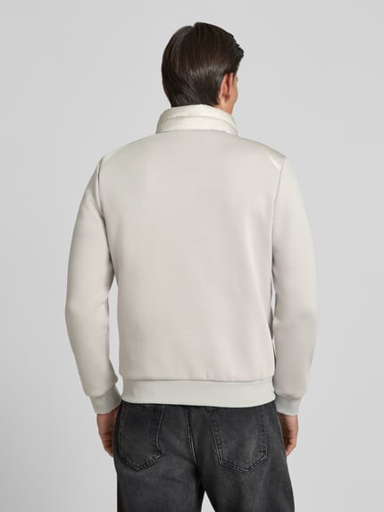 Męski model nosi Jacke mit Label-Patch und Stehkragen od Antony Morato, krój slim fit, kolor jasnoszary, widok całej sylwetki z tyłu.