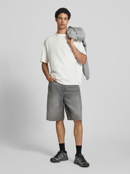 Männermodel trägt Jeansshorts im Used-Look mit Eingrifftaschen von REVIEW, Grau, Reine Baumwolle, Relaxed-Fit, Ganzkörperansicht von vorne.