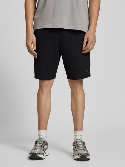 Männermodel trägt Straight Fit Shorts mit Strukturmuster von G-Star Raw, Elastischer-Material-Mix mit Baumwoll-Anteil, Logo-Detail, Ganzkörperansicht von vorne.