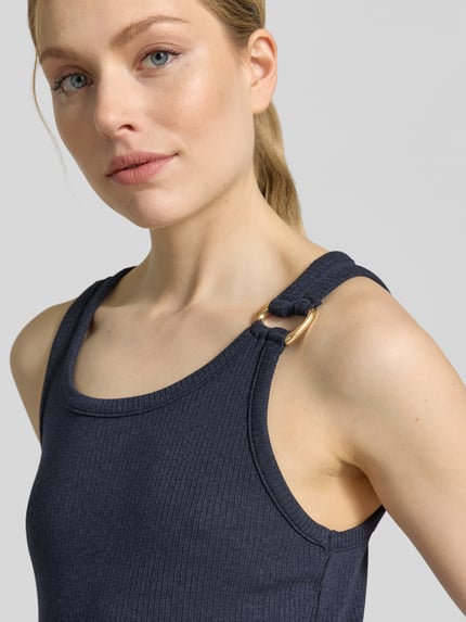 Frauenmodel trägt Regular Fit Tank Top aus Viskose-Mix Modell 'KIKI' von Vero Moda in Unifarbe mit Zier-Applikation, Nahaufnahme Oberkörper.