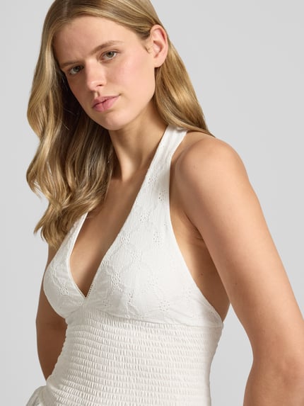 Frauenmodel trägt Neckholder-Blusentop mit V-Ausschnitt von Gina Tricot in Weiß, Material-Mix mit Stretch-Anteil, Smok-Detail, Taillierter Schnitt, Nahaufnahme Oberkörper. Rückenlänge bei Größe S: 53 cm.