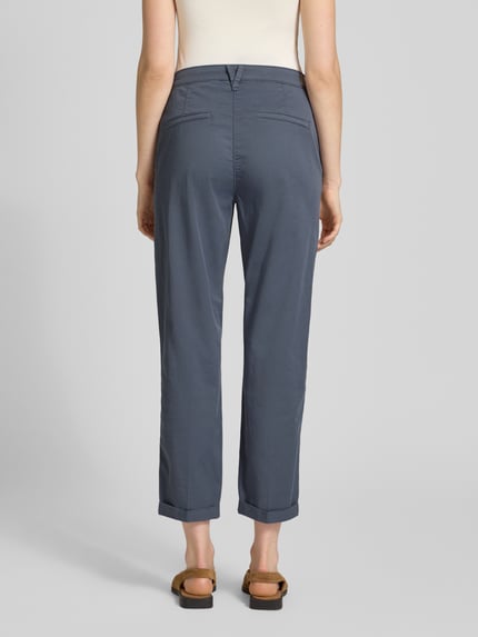 Vrouwenmodel draagt Straight Fit Chino in verkürzter Passform van MAC, dames chino van katoenmix, steekzakken, knoop- en ritssluiting, bandwijdte maat 36: 40 cm, binnenbeenlengte maat 36: 67 cm, ganzkörperansicht rückansicht.