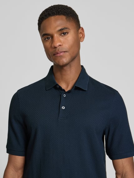 Männermodel trägt Slim Fit Poloshirt mit Strukturmuster von bugatti in Dunkelblau, reine Baumwolle, Knopfleiste, Nahaufnahme Oberkörper