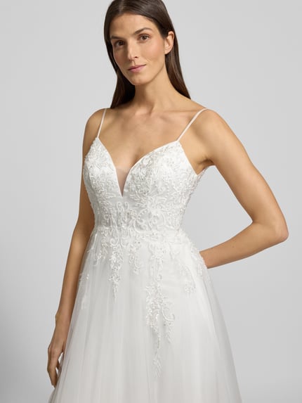 Vrouwenmodel draagt Brautkleid mit Details aus Spitze van LUXUAR FASHION, wit, V-hals, taillerend, kantdetails, close-up bovenlichaam.