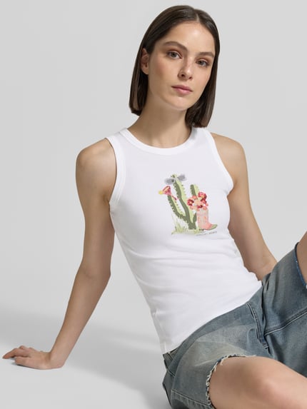 Vrouwenmodel draagt Tanktop mit Motiv-Print und Ziersteinbesatz van Marc Cain, wit katoen-elastaan, slim fit, ronde hals, print en sierstenen, detailopname bovenlichaam.