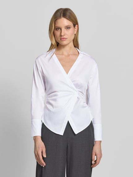 Vrouwenmodel draagt Bluse mit Raffungen und V-Ausschnitt van comma, witte katoenmix met stretch, getailleerde fit, V-hals, plooien, voorkant, close-up bovenlichaam.