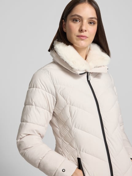 Frauenmodel trägt Steppjacke mit Zweiwege-Reißverschluss Modell 'COSETTE' von khujo, Slim Fit, Stehkragen, cremefarben, Nahaufnahme Oberkörper.